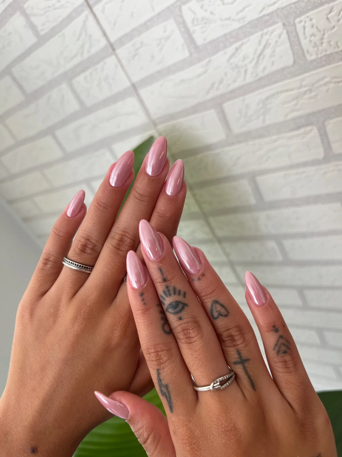 Manos con uñas largas almendradas en rosa nacarado con efecto cromado